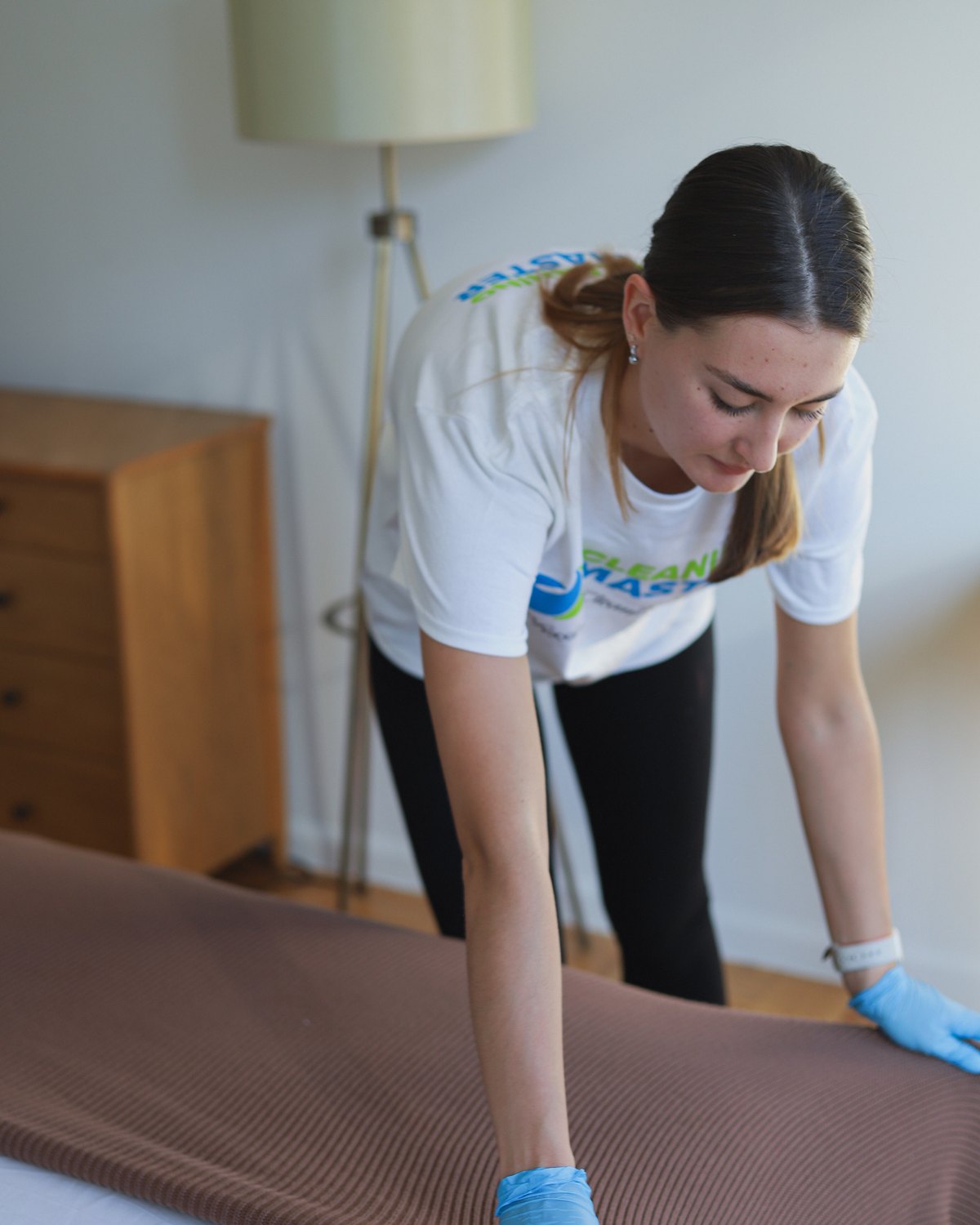 Cleaning Master professional smoothing a knit throw over upholstery in a New York home