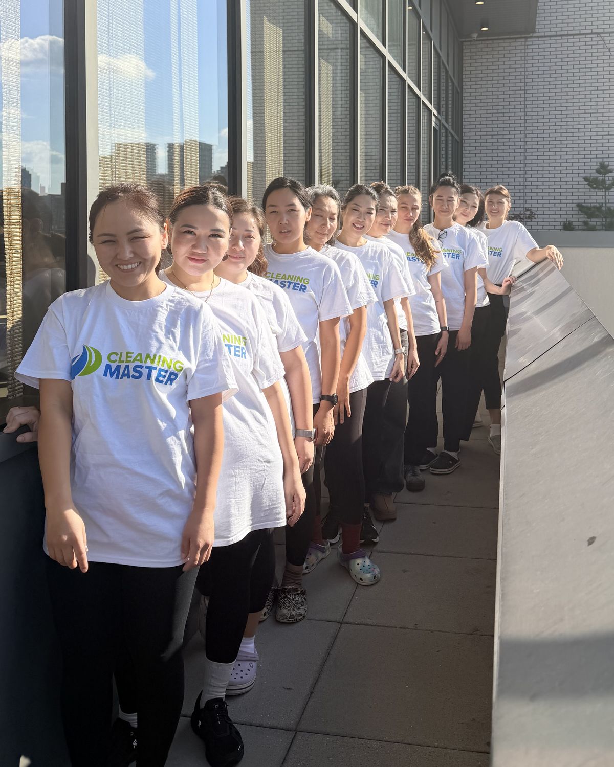 The Cleaning Master team lined up on a rooftop terrace with the New York skyline behind