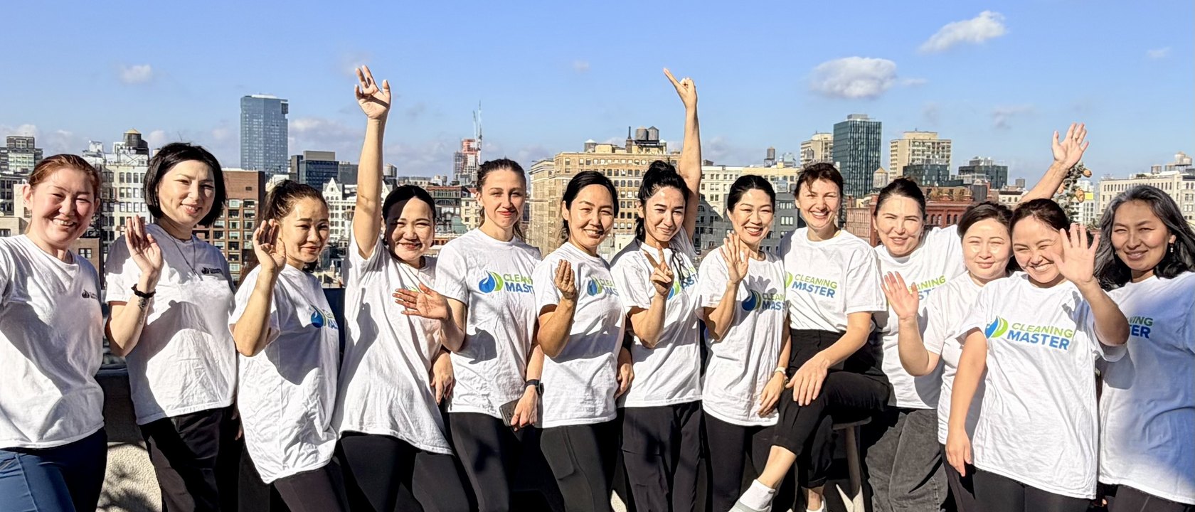 The Cleaning Master team of more than 100 professionals on a rooftop with the NYC skyline