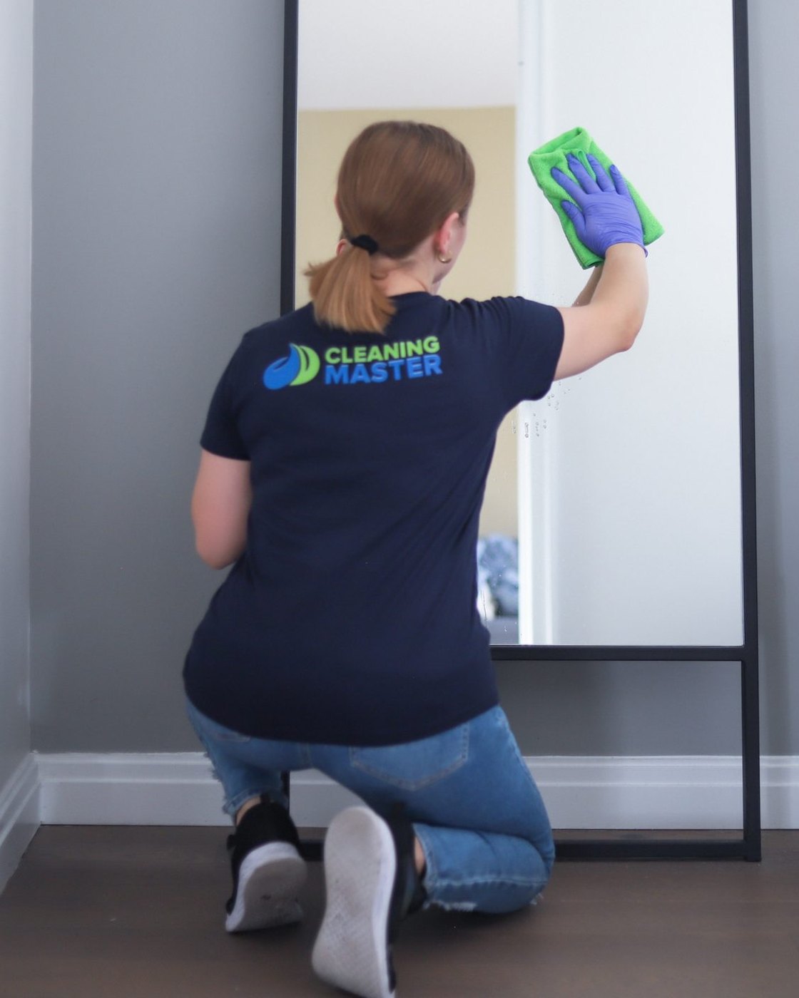 Cleaning Master professional in navy uniform detailing a door and trim after construction work