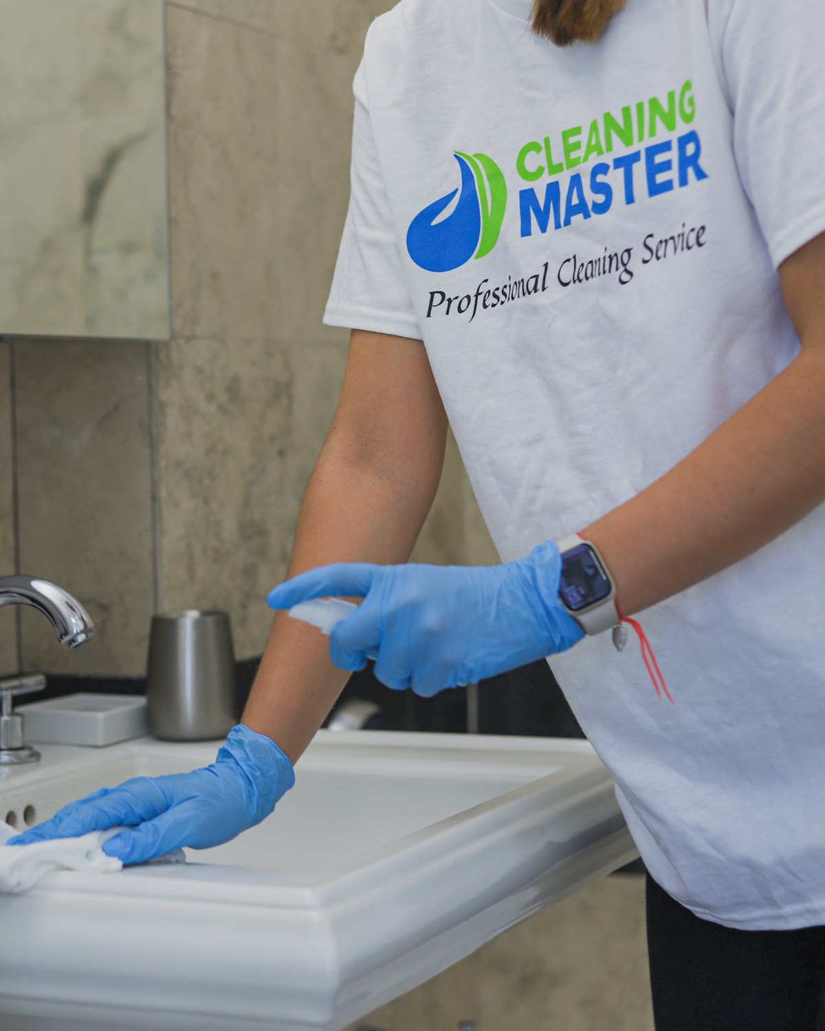 Cleaning Master professional wiping a bathroom sink with a microfiber cloth