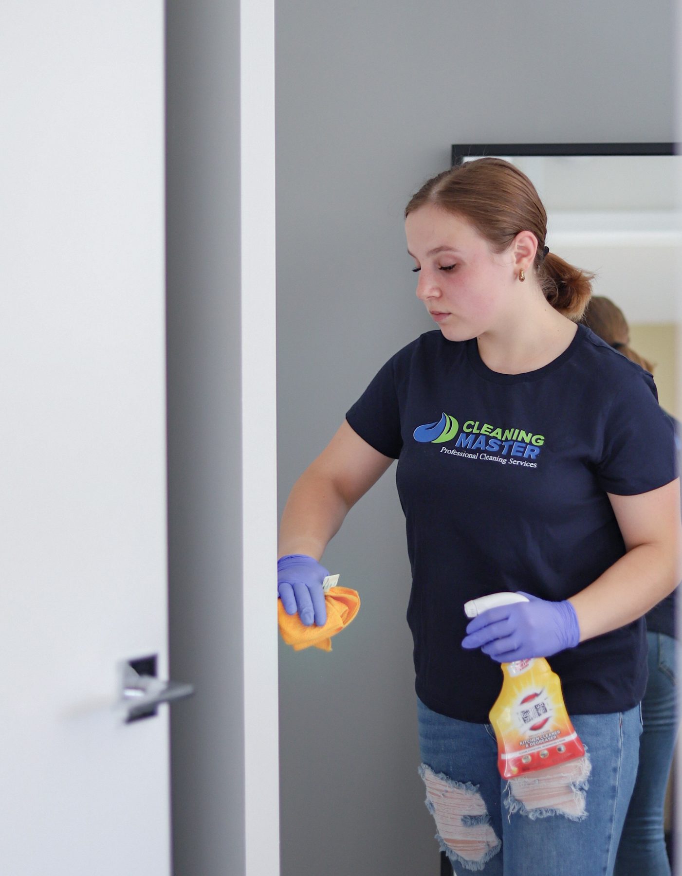 Cleaning Master professional in navy team uniform carrying supplies between rooms