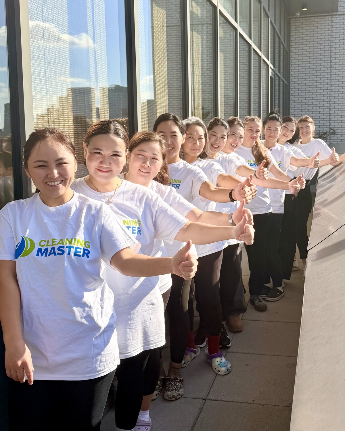 The Cleaning Master team lined up on a sunny New York rooftop terrace