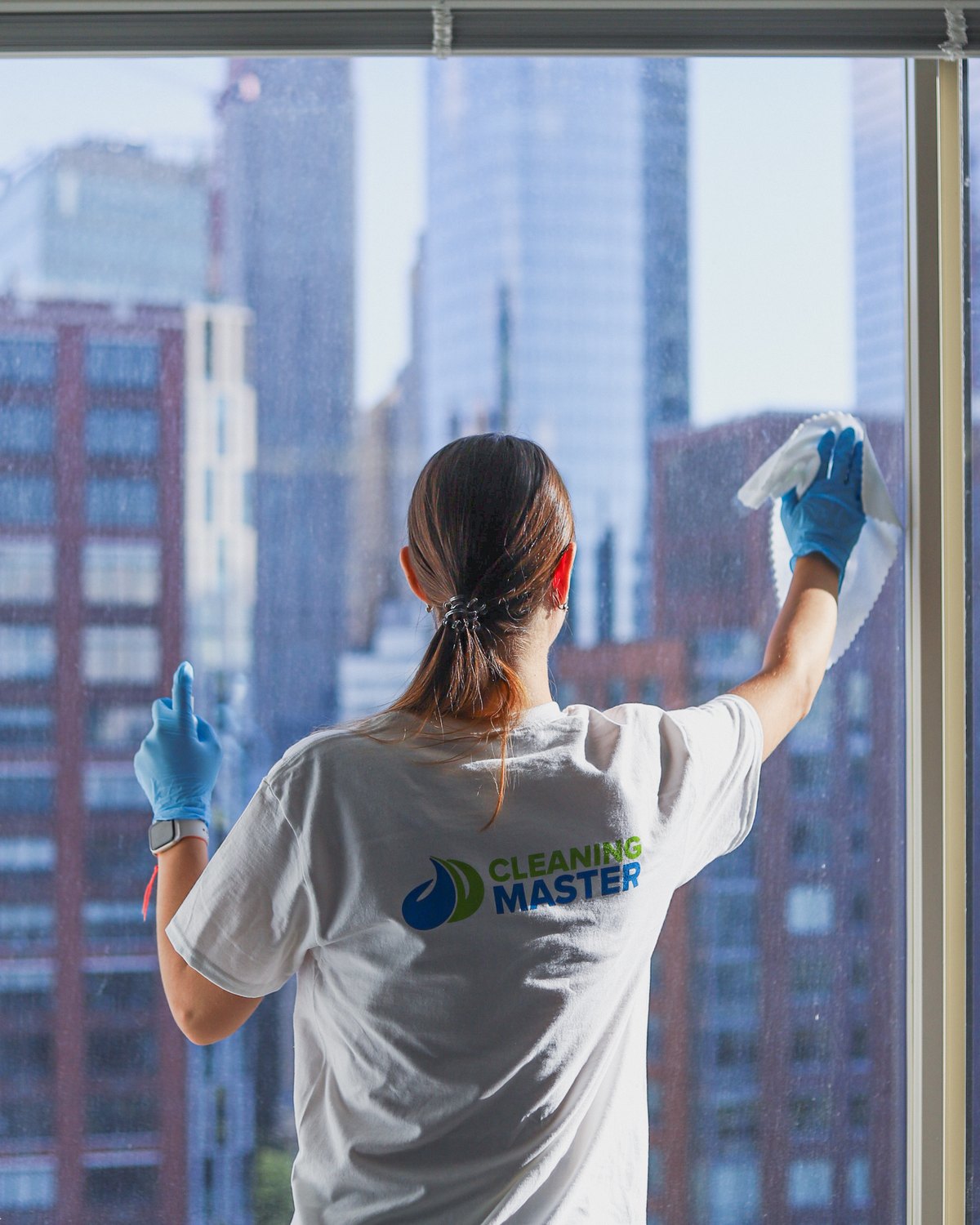 Cleaning Master professional cleaning a Manhattan high-rise window with the skyline behind