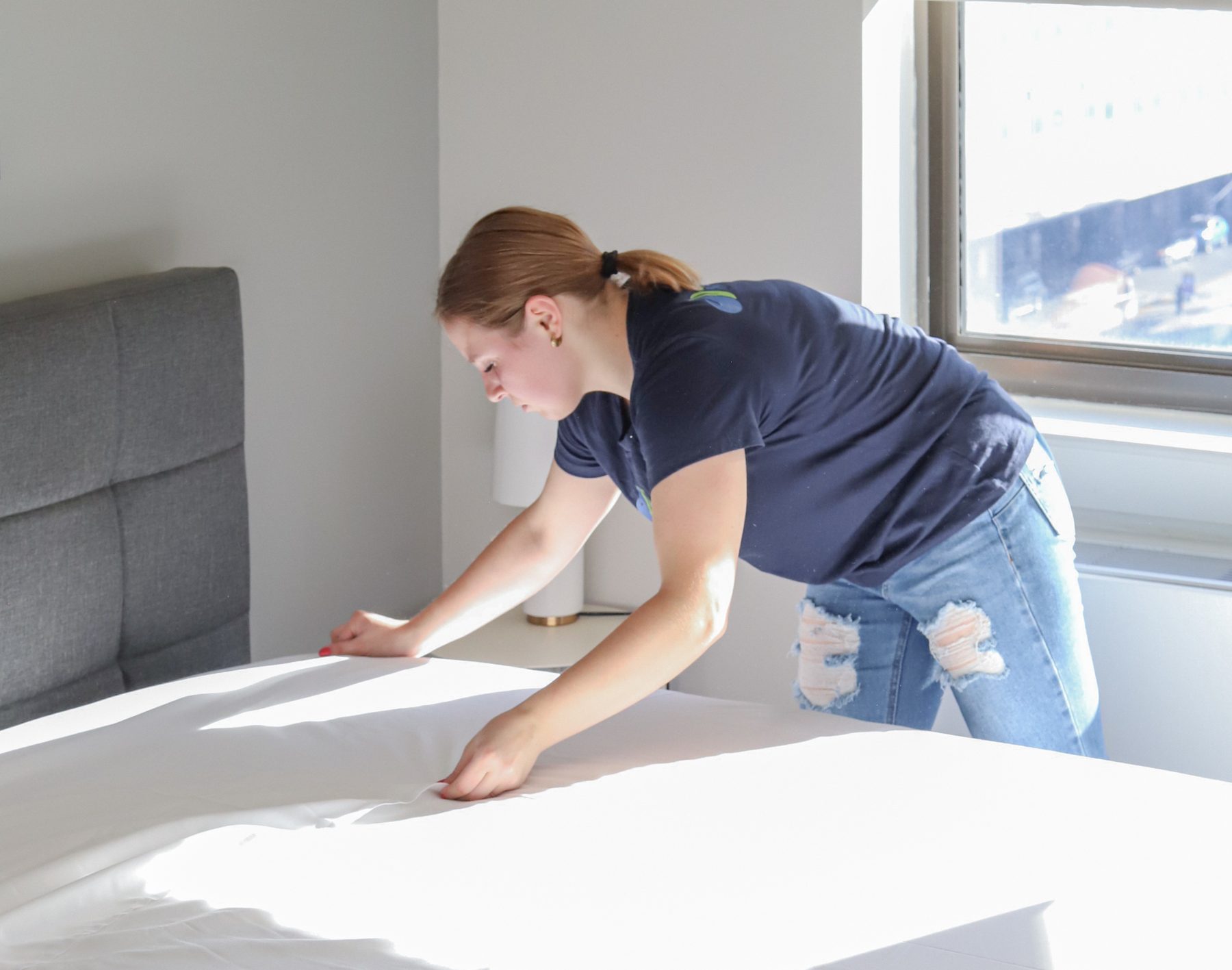 Cleaning Master professional making a bed in a student housing room